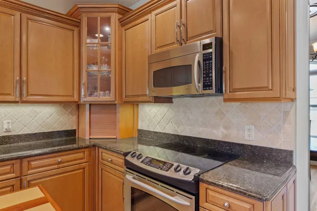 a kitchen with wooden cabinets and a stove top oven