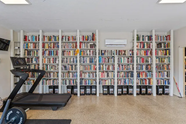 a living room with lots of furniture and a book shelf