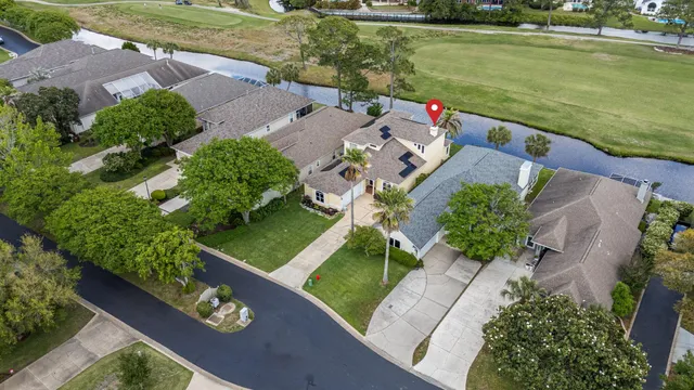 an aerial view of a house with a garden and lake view