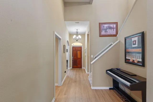 a view of a hallway with wooden floor and stairs
