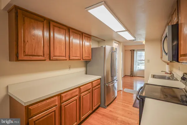 a kitchen with stainless steel appliances sink refrigerator and cabinets