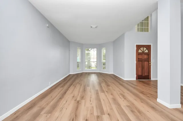 a view of a room with wooden floor staircase and a kitchen