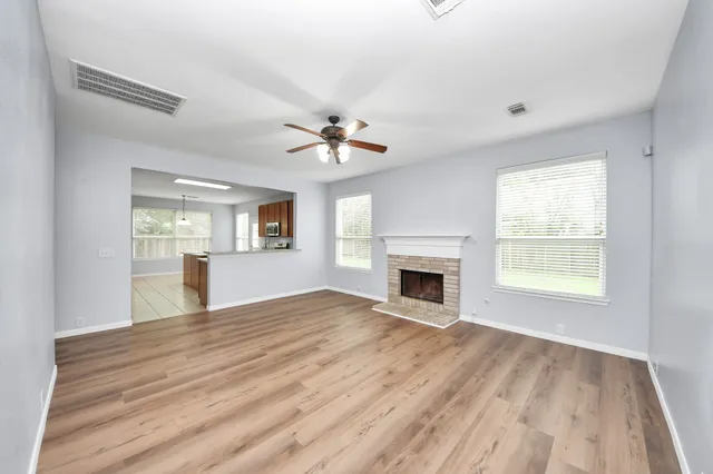 a view of an empty room with window and fireplace