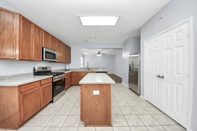 a kitchen with stainless steel appliances granite countertop a stove top oven a sink dishwasher and a refrigerator