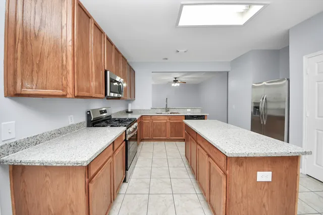 a kitchen with granite countertop a refrigerator and a stove top oven
