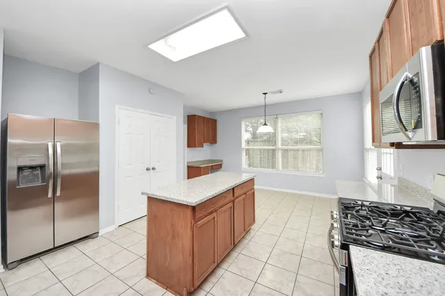 a kitchen with stainless steel appliances granite countertop a refrigerator and a stove