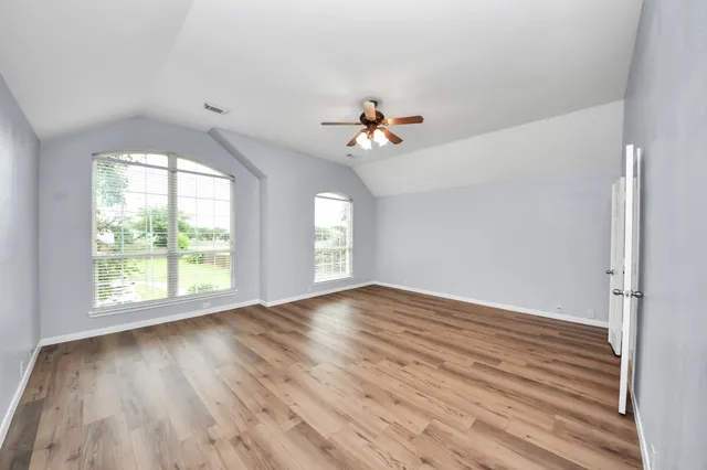 a view of an empty room with a chandelier fan