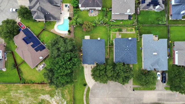 a view of a house with a yard and a large tree