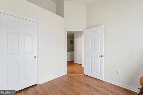 an empty room with wooden floor & closet area