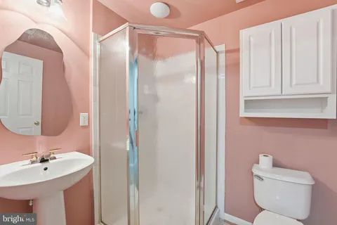 a bathroom with a sink a toilet and shower
