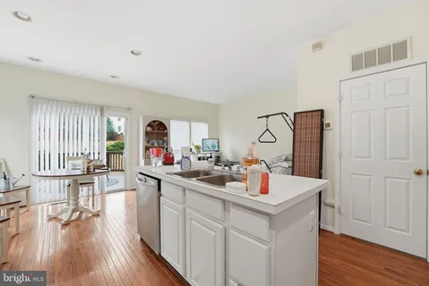 a kitchen with a sink cabinets and wooden floor