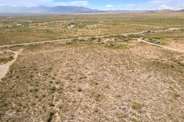 a view of a dry yard with mountains in the background