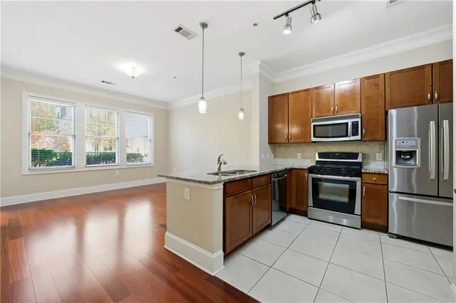 a kitchen with stainless steel appliances granite countertop a stove a refrigerator and a microwave