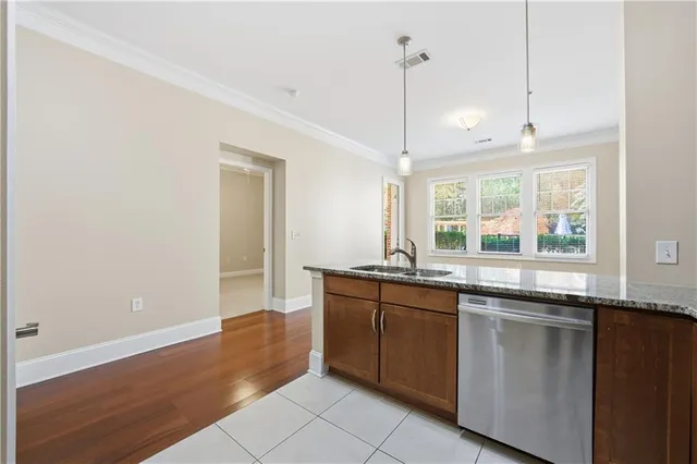 a kitchen with granite countertop a sink and a wooden floor