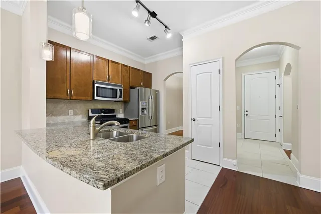 a kitchen with kitchen island granite countertop a sink refrigerator and microwave