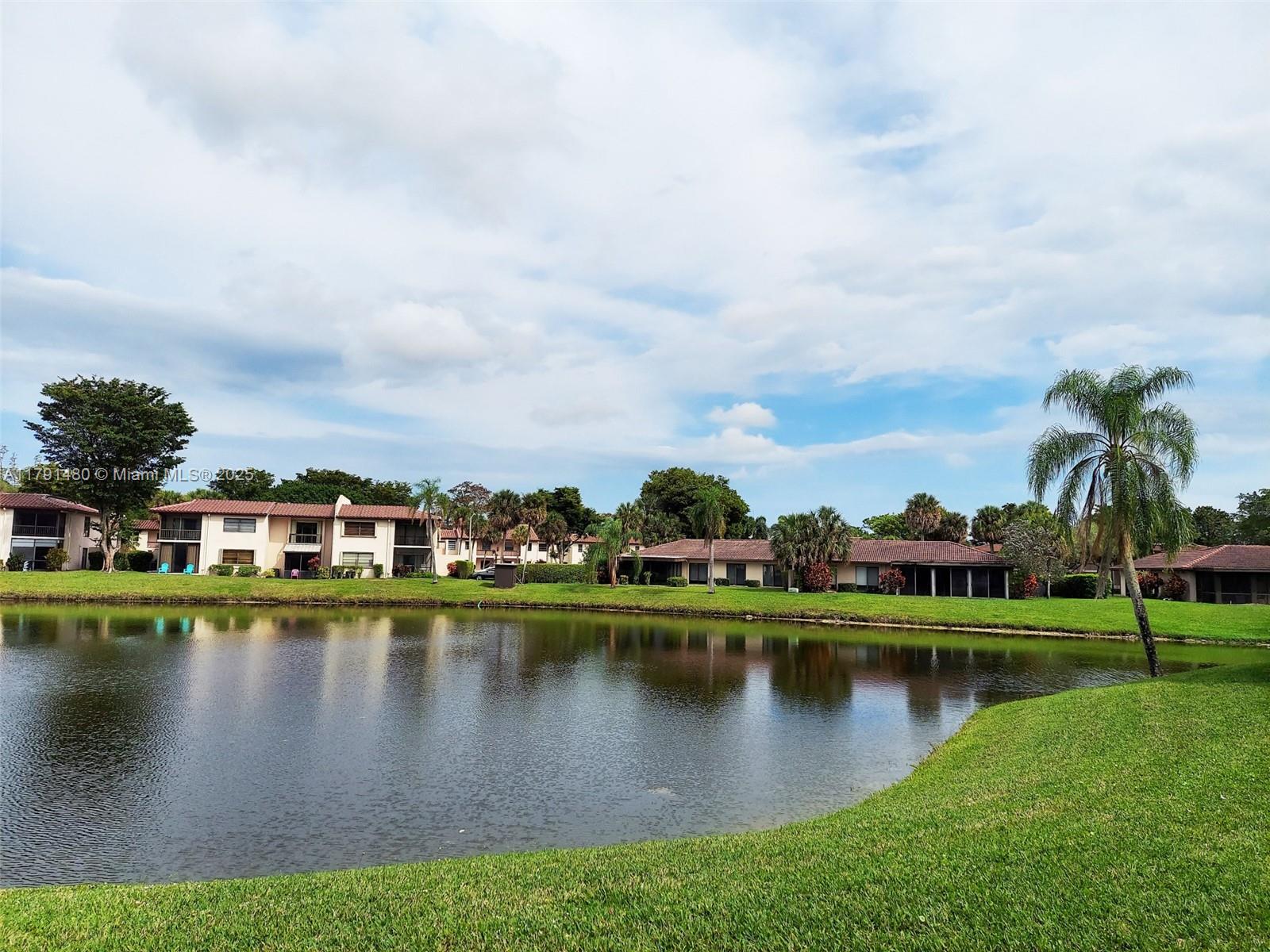 21338 Juego Circle, Unit 11C Boca Raton, FL 33433 - Photo 11 of 17 a view of a lake with houses in the back