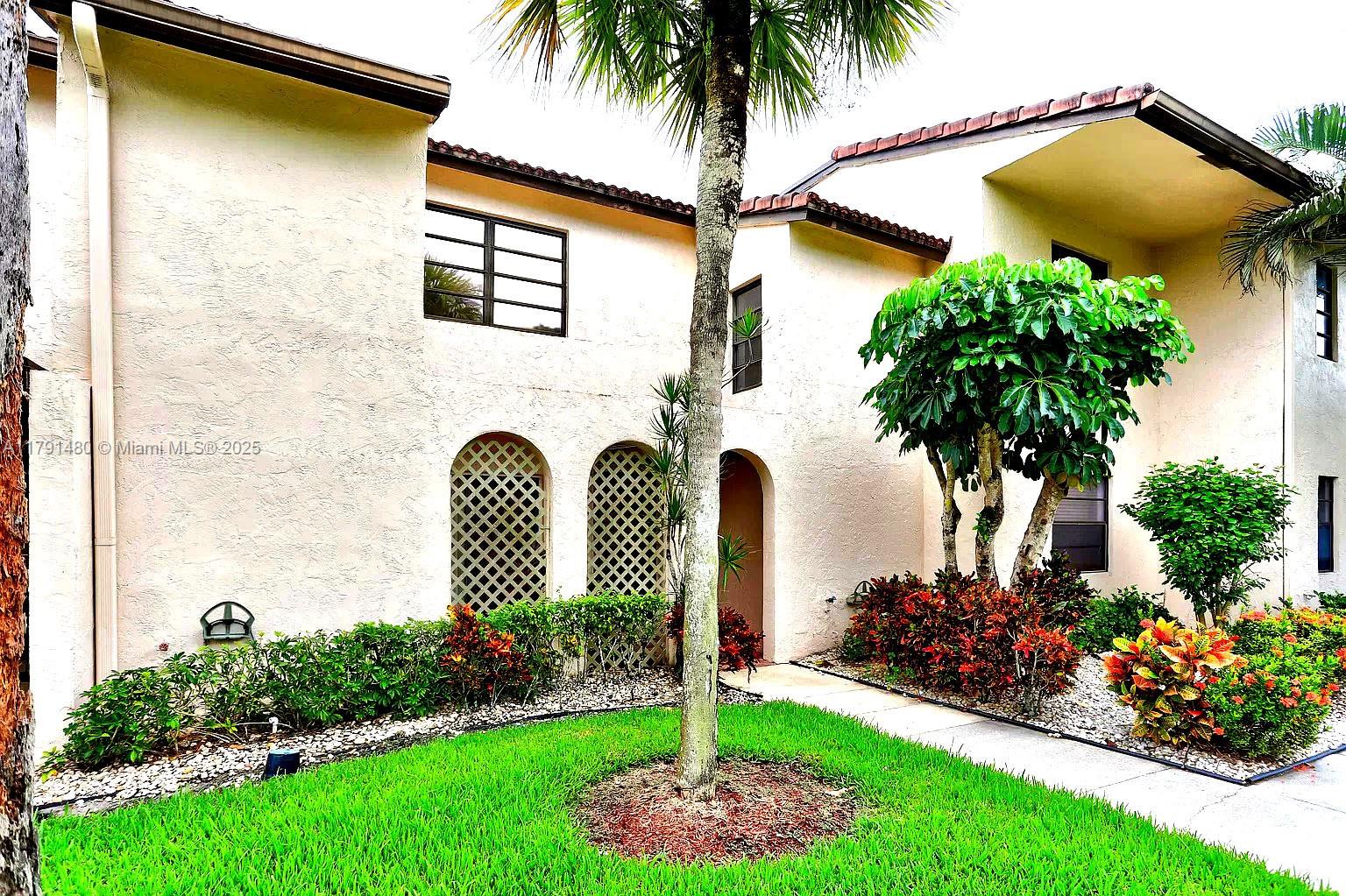 21338 Juego Circle, Unit 11C Boca Raton, FL 33433 - Photo 2 of 17 a front view of a house with garden