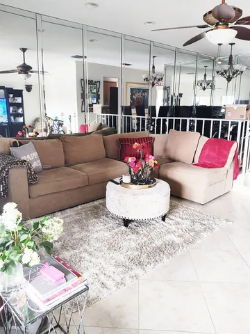 a living room with furniture kitchen and a chandelier