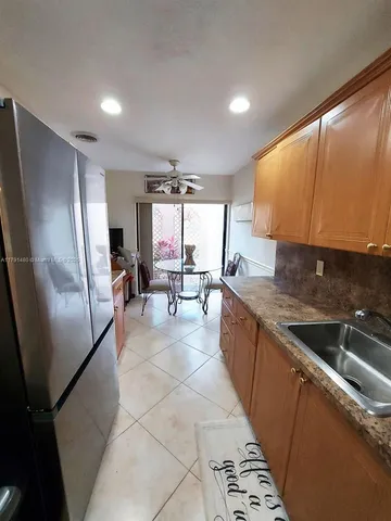 a open kitchen with stainless steel appliances granite countertop a sink refrigerator and microwave