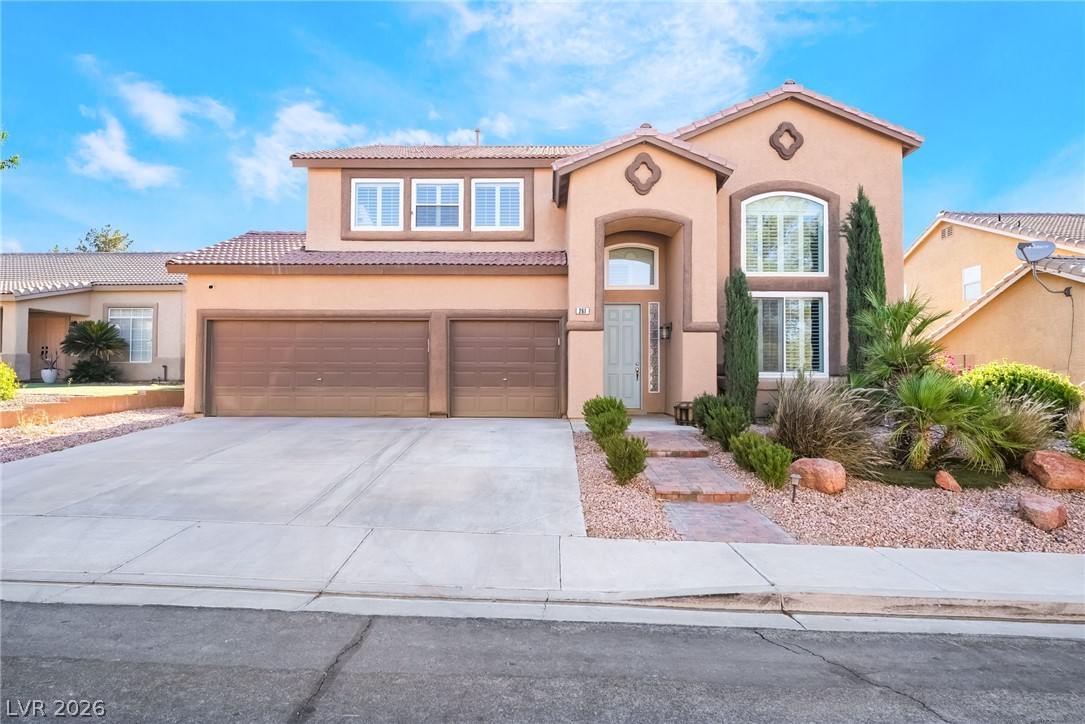 261 Timber Hollow Street Henderson, NV 89012 - Photo 3 of 51 A well-manicured desert landscape frames this two-story residence with a generous driveway and attached garage.