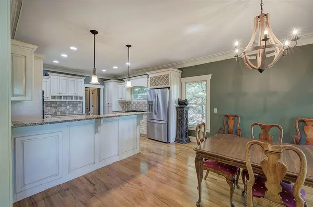 a kitchen with stainless steel appliances granite countertop a refrigerator and a stove top oven