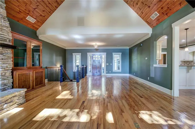 a kitchen with stainless steel appliances a table chairs in it and wooden floors