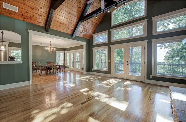 a dining room with wooden floor a chandelier a wooden table and chairs