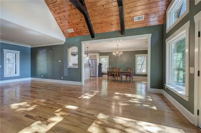 a kitchen with granite countertop white cabinets stainless steel appliances and wooden floor