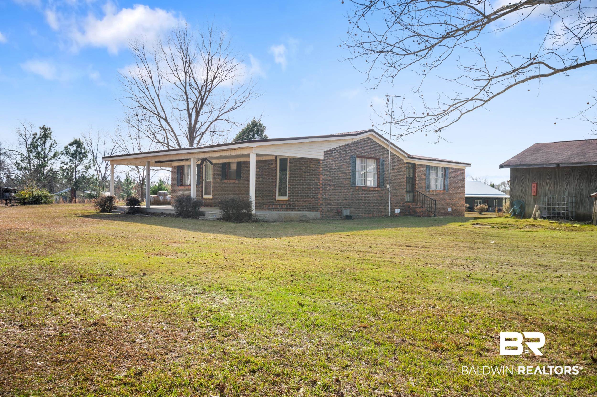 57623 Mary Hadley Road Perdido, AL 36562 - Photo 23 of 34 Rear view of house featuring brick siding, a yard, and covered porch