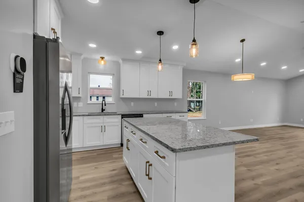 a kitchen with a sink refrigerator and microwave