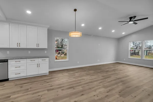 a room with chandelier and wooden floors