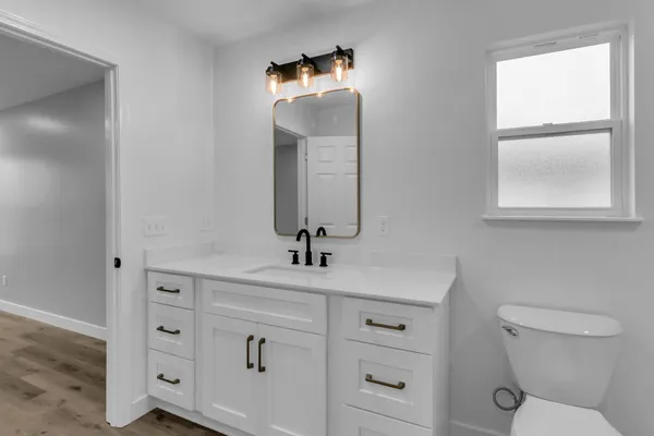 a bathroom with a toilet sink and mirror