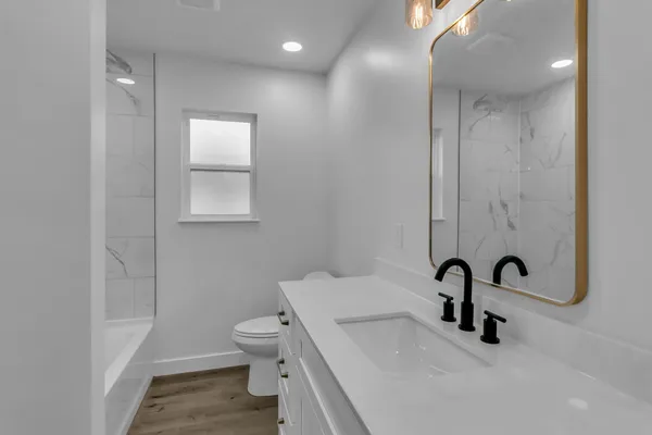 a bathroom with a sink a toilet and a mirror