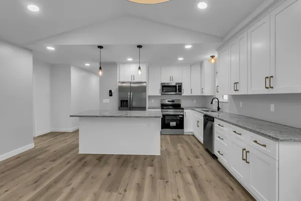 a kitchen with white cabinets and appliances