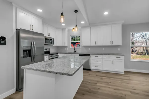 a kitchen with stainless steel appliances granite countertop a sink stove and refrigerator