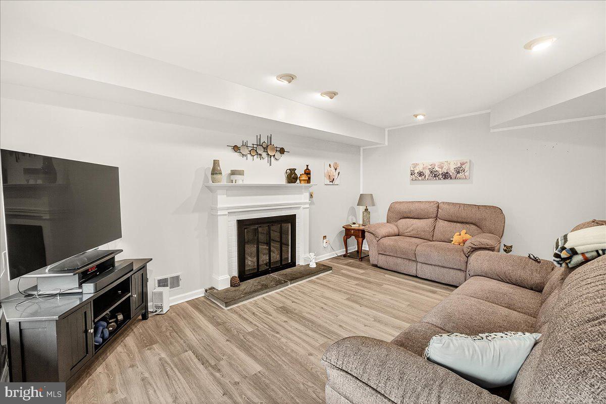 19624 Westerly Avenue Poolesville, MD 20837 - Photo 19 of 44 a living room with furniture a flat screen tv and a fireplace