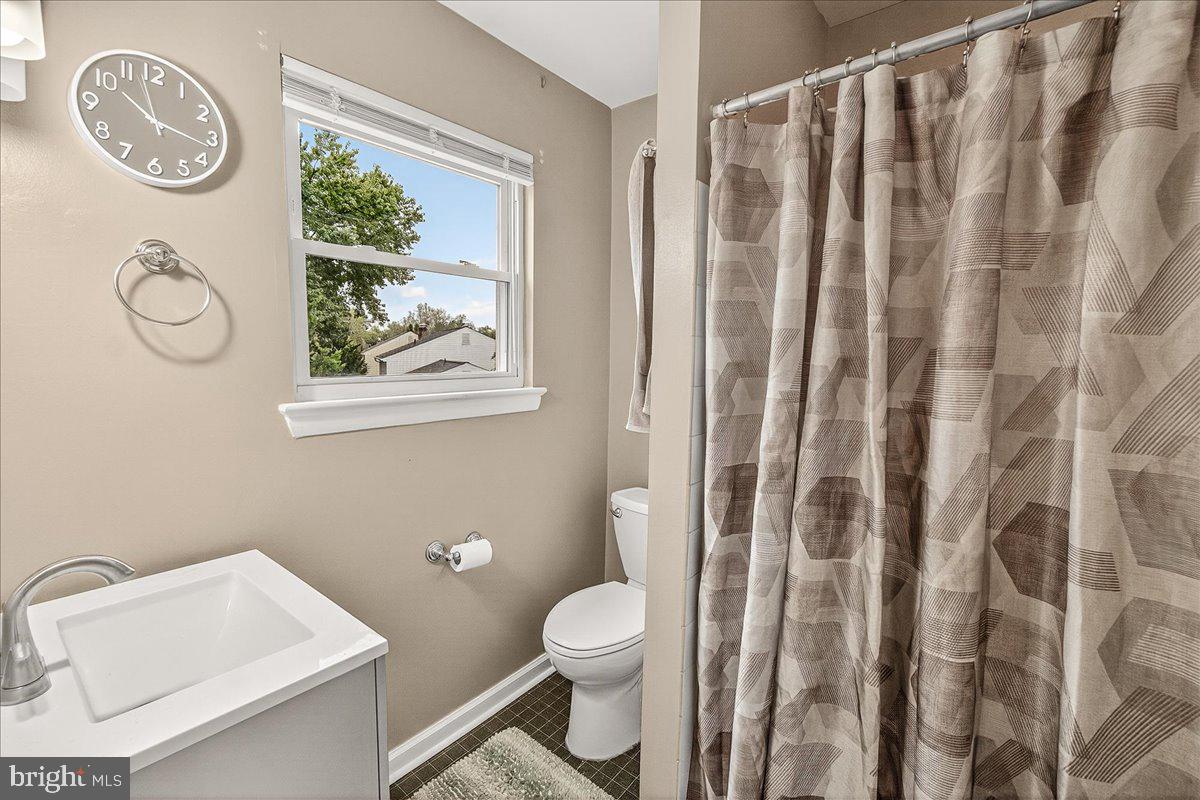 19624 Westerly Avenue Poolesville, MD 20837 - Photo 31 of 44 a bathroom with a toilet and a shower curtain