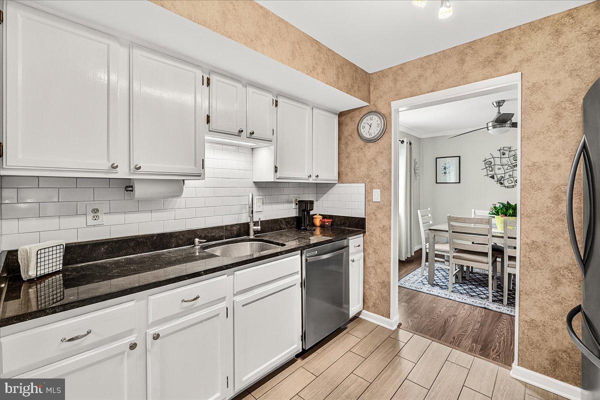 19624 Westerly Avenue Poolesville, MD 20837 - Photo 9 of 44 a kitchen with granite countertop a sink a stove and cabinets