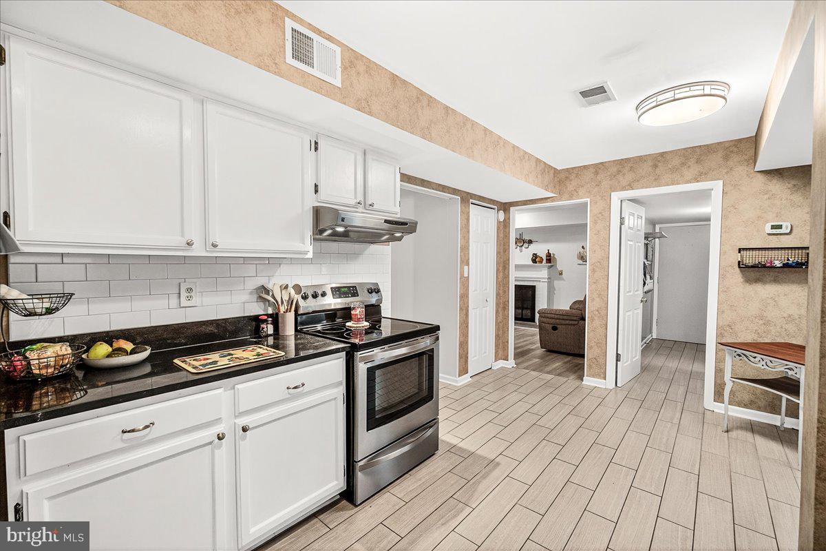 19624 Westerly Avenue Poolesville, MD 20837 - Photo 10 of 44 a kitchen with stainless steel appliances granite countertop a stove a refrigerator and a white cabinets