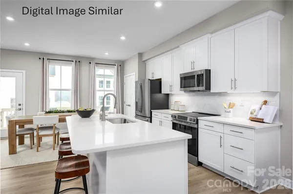a kitchen with stainless steel appliances kitchen island granite countertop a stove a sink a dining table and chairs