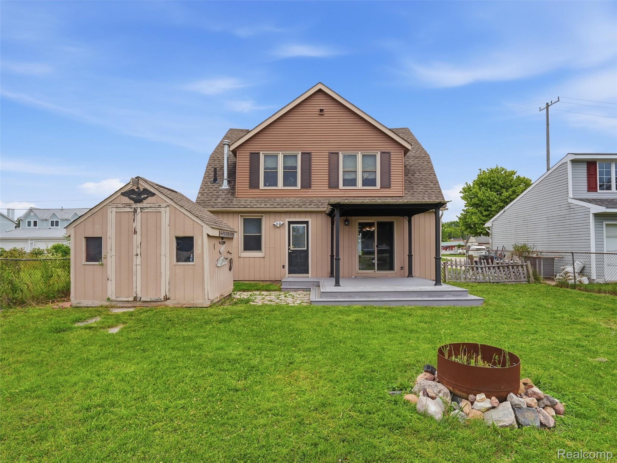 117 Kenyon Road Algonac, MI 48001 - Photo 37 of 47 Rear exterior featuring a covered patio with dark columns, sliding glass door access, and a wood-look deck