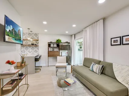 a living room with furniture and kitchen view