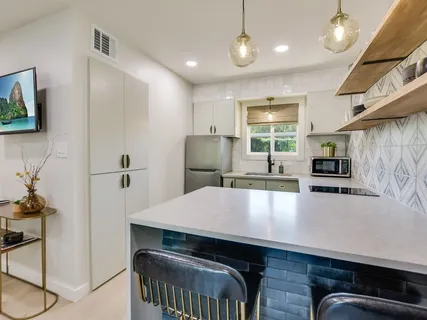 a kitchen with kitchen island a stove and a refrigerator with wooden floor
