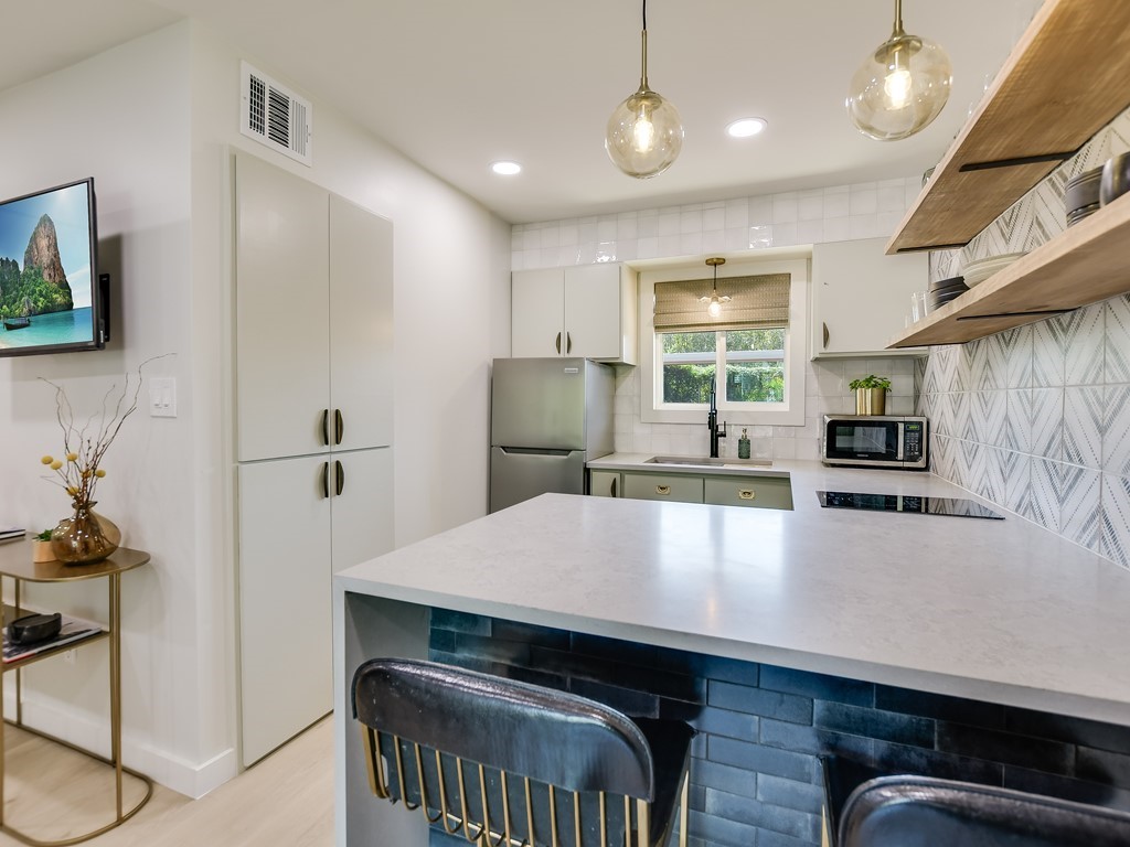 500 East Riverside Drive, Unit 169 Austin, TX 78704 - Photo 10 of 19 a kitchen with kitchen island a stove and a refrigerator with wooden floor