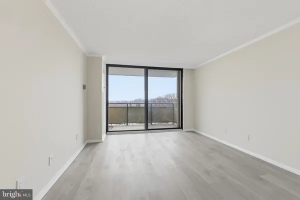 an empty room with wooden floor and sliding door
