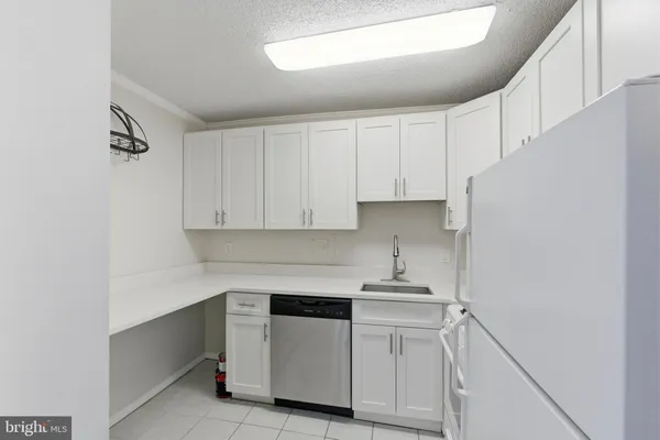 a kitchen with white cabinets and white appliances