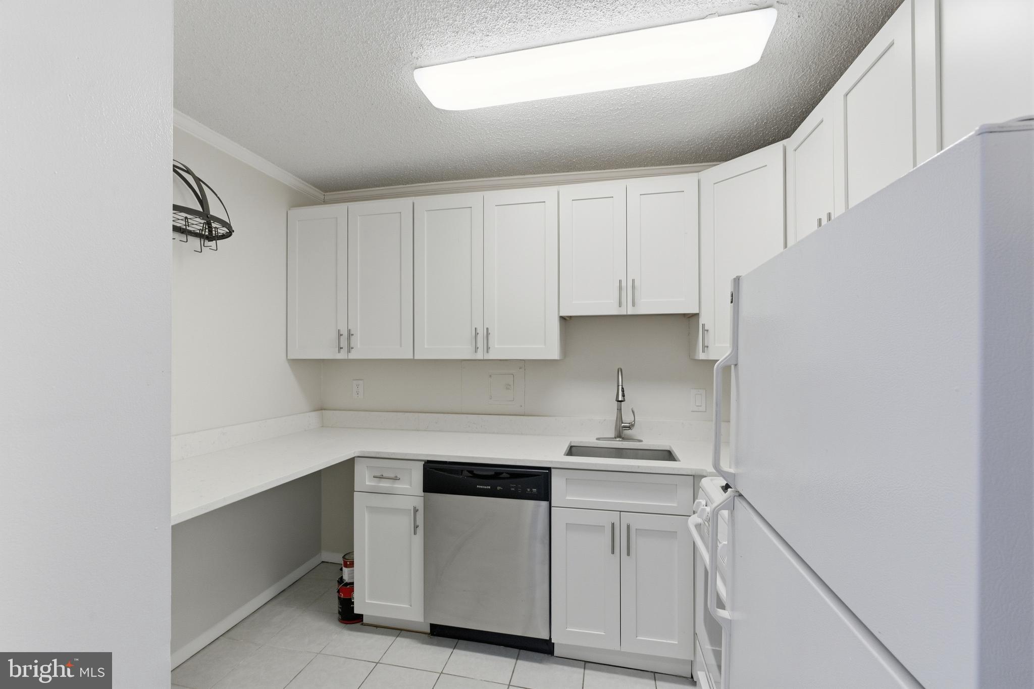 5225 Pooks Hill Road, Unit 1206S Bethesda, MD 20814 - Photo 6 of 12 a kitchen with white cabinets and white appliances