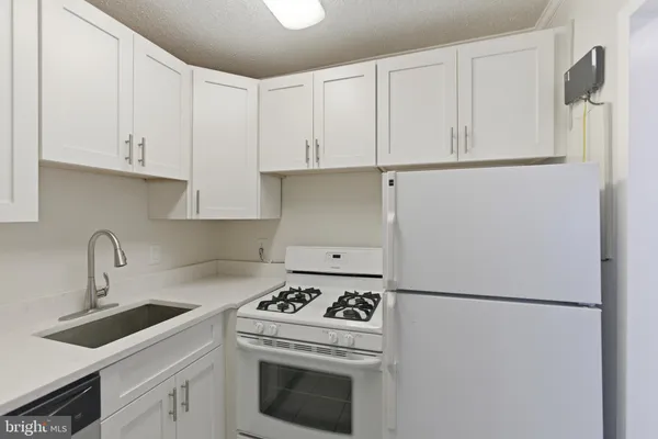 a kitchen with a white stove top oven and sink