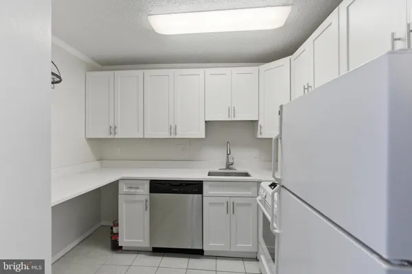 a kitchen with white cabinets and white appliances