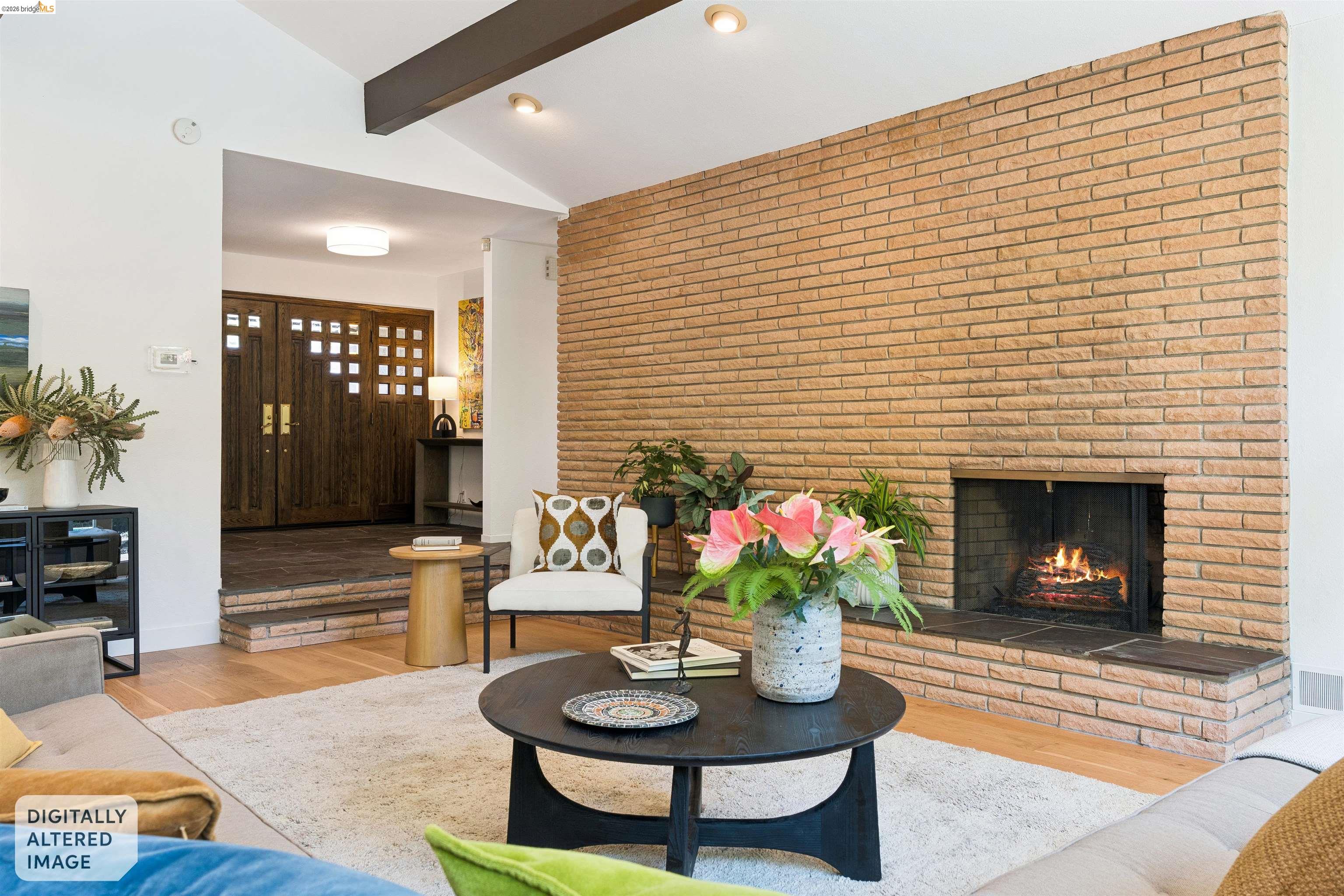 7 Jo Lin Court El Sobrante, CA 94803 - Photo 33 of 99 Living area featuring a floor-to-ceiling brick fireplace with hearth, vaulted ceilings with exposed beams, wood-finish flooring, and a recessed entry with double doors